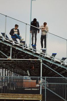 three skateboarders are standing on top of the stairs