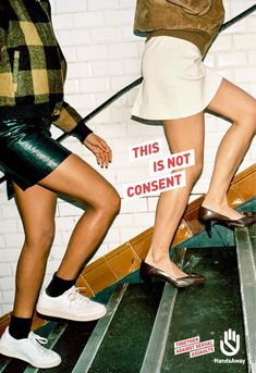 two women walking down an escalator with signs on the handrails that read this is not consent