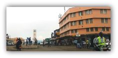 a group of people walking down a street next to tall buildings