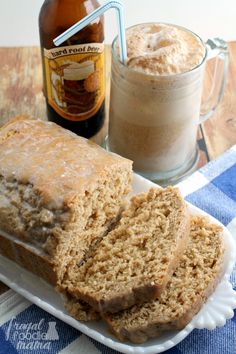 a loaf of bread sitting on top of a white plate next to a bottle of beer