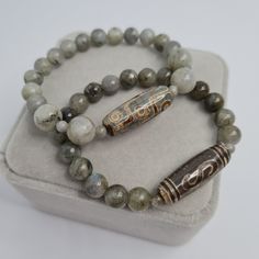 Agate DZI bracelet. Tibetan talisman. Labradorite beads stretch bracelet. Tibetan talisman for a gift. Bracelet size made to order. Please send me the size of your wrist so the bracelet will fit perfectly. Beads size: Dzi - 2.9×1 cm/1.17×0.42 inches. Labradorite - 4, 6, and 8 mm/0.17, 0.22 and 0.32 inches. If you choose to pack No.2, leave me a message about which stamp you would like (Crown, Cloverleaf, Just Smile). I will choose the color of the stamp at my discretion if you do not have any ot Spiritual Bracelets With Polished Beads For Meditation, Spiritual Polished Beads Bracelets For Meditation, Symbolic Natural Stones Beaded Bracelets As Gift, Spiritual Stretch Bracelet With Round Beads, Spiritual Gemstone Beads Stretch Bracelet For Meditation, Spiritual Beaded Bracelets With Natural Stones For Good Luck, Spiritual Gemstone Beads Bracelet For Meditation, Symbolic Beaded Bracelets With Natural Stones For Meditation, Spiritual Stretch Bracelet With Gemstone Beads For Healing