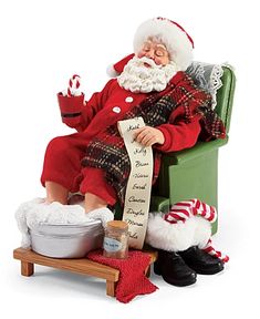 a santa clause doll sitting on a green chair