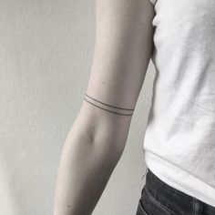 a woman's arm with a single line tattoo on the left side of her arm