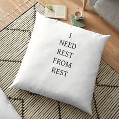 a pillow that says i need rest from rest on the floor next to a coffee cup