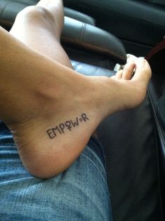 a person with a tattoo on their foot that says epipwrr in black ink