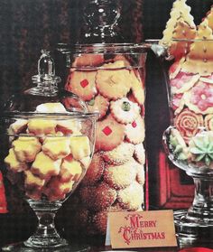 an advertisement for christmas cookies and other treats in glass containers on a table with red ribbon