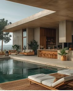 an outdoor pool with lounge chairs and tables next to it, overlooking the water's edge