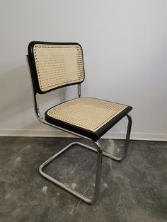 a black and white chair sitting on top of a cement floor