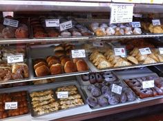 a display case filled with lots of different types of doughnuts and pastries