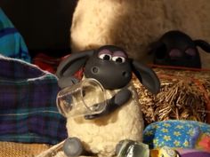 a stuffed sheep with a magnifying glass in its mouth