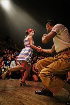 a man and woman dancing on stage in front of an audience