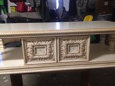 a white table with two drawers on it in a room filled with other furniture and items