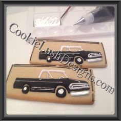 two cookies decorated with black and white cars on top of a table next to a pen