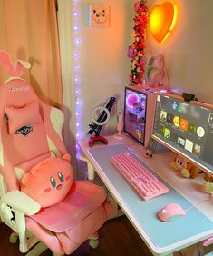 a pink chair sitting next to a computer on top of a desk in front of a monitor