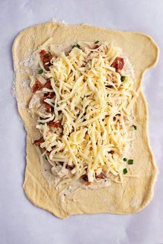 an uncooked pizza dough with meat and cheese