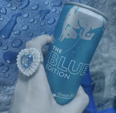 a woman holding onto a blue cup with a ring on it