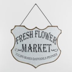 a sign hanging from the side of a wall that says fresh flower market, tulips roses daffodils ponies