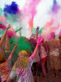 many people are throwing colored powder on each other in the air at a color run