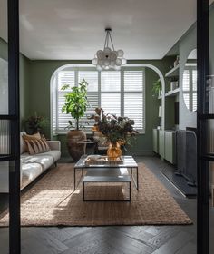 a living room filled with furniture and plants