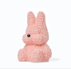 a pink stuffed animal sitting on top of a white surface