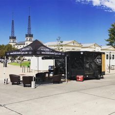 an outdoor tent with tables and chairs in front of it on the sidewalk next to a building