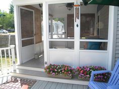 a porch with flowers and potted plants on it