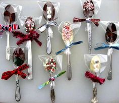 six spoons are wrapped in plastic and decorated with candy canes, candies, and snowmen