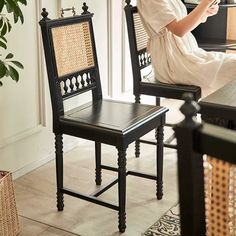 a woman sitting in a chair looking at her cell phone