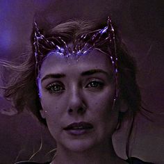 a close up of a person wearing a crown on their head with purple light behind her