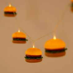 hamburger string lights hanging from strings on a wall in the shape of buns with cheese and lettuce