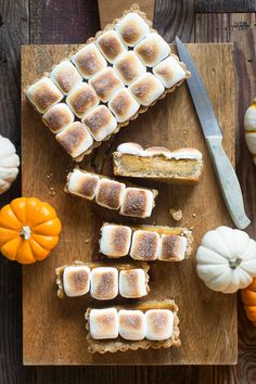 several pieces of bread with marshmallows on them and a knife next to it