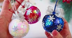 two christmas ornaments being held in their hands