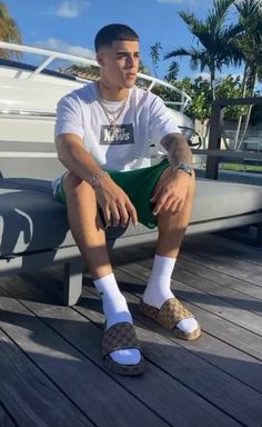 a man sitting on top of a wooden bench next to a boat