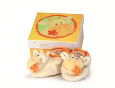 a pair of slippers with giraffes on them in front of a box