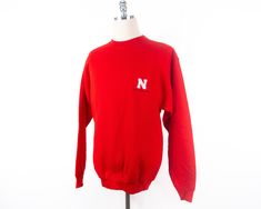 "Nebraska sweatshirt in new condition. Size: multiple sizes, please see measurements Measurements taken with garment laid flat. MEDIUM Shoulder: 21.5\" Chest: 21.5\" Length: 29.5\" Sleeve: 25.5\" LARGE Shoulder: 23.5\" Chest: 23.25\" Length: 31\" Sleeve: 25.5\" X-LARGE Shoulder: 25.5\" Chest: 25\" Length: 31\" Sleeve: 25.5\" Material: 80% Cotton 20% Fortrel Polyester Label: Olympus Superweight Please message me with questions or for additional photos. View other items from my shop here: www.etsy Nebraska Sweatshirt, College Gear, Red Crewneck, Vintage University, Ncaa Football, Nebraska, Ncaa, Crewneck Sweatshirt, High Fashion