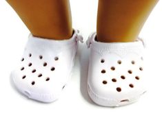 a close up of a person's feet wearing white crocs with holes on them