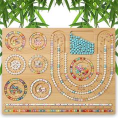 a wooden board with beads on it in front of some plants and leaves, which are part of a puzzle