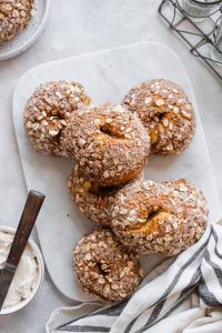 several donuts are sitting on a plate next to a bowl of yogurt