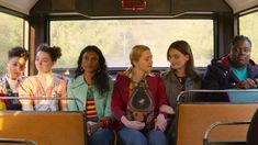 a group of women sitting on top of a bus