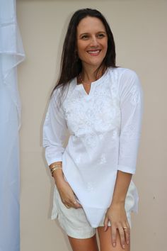 White embroidered women blouse on cotton fabric  Theigh length tunic /Kurta with pintuck style is one of the georgious attire for warm whether. Airy and light weight companion for a hot summer day. This beautiful Hand embroidered tunic/top is ideal for any functions / parties. If you want classic look then pair it with leggings, skinny jeans, capri. This is contemporary reflection of traditional India Chikan embroidered ethnics which had originated centuries ago in Lucknow. Chikansazi being the exquisite needle work of fine and delicate floral patterns. It's cool cotton and hand embroidery by artisans makes it look elegant. Fabric: 100% soft cotton voile Sizes:  S/ M ( Below are garment measurements +/- 1" ). The Tunic has straight fit - Bust, Waist and Hip measurements are same. Size XS White Cotton Tops For Eid, White Tunic With Chikankari Embroidery, Traditional White Chikankari Embroidered Top, White Long Sleeve Tunic With Chikankari Embroidery, White Cotton Tunic With Floral Embroidery, White Long Sleeve Chikankari Tunic, White Tops With Resham Embroidery, Floral Embroidered Straight Kurta Blouse For Summer, White Chikankari Embroidered Beach Blouse