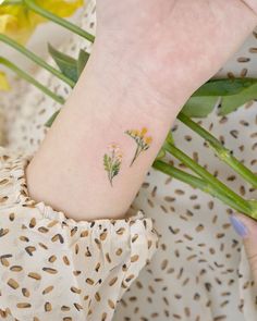 a small flower tattoo on the wrist