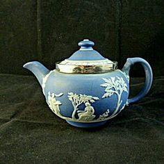 a blue tea pot sitting on top of a black cloth