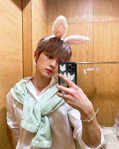 a person taking a selfie in front of a mirror with bunny ears on their head