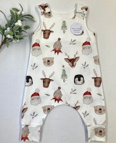 "Santa's friends print organic romper, fun baby and toddler wear, baby gift, baby clothes, stretchy dungarees, handmade to order. This beautiful organic romper is the ideal baby outfit, bringing festive joy and fun to baby wear.  Rompers are made using a harem style pattern  to provide extra room for your little one to grow and move freely. I use high quality GOTS certified, organic jersey which is perfect for delicate skin.  Each romper has two KAM shoulder poppers to provide quick and easy nap White Printed Playful Jumpsuits And Rompers, Playful Cotton Bodysuit As A Gift, Cute Cotton Christmas Onesie, Cute Christmas Cotton Onesie, Cute Cotton Onesie For Holidays, Playful White Bodysuit As A Gift, Playful White Bodysuit As Gift, Playful White Bodysuit Gift, Playful White Printed Bubble Romper