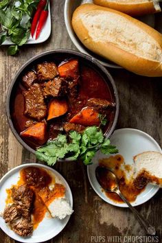 beef stew in a pot with bread and parsley on the side for garnish