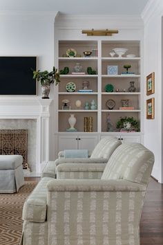 a living room filled with lots of furniture and bookshelves next to a fire place