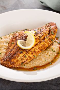 grilled fish with lemon and parmesan sauce in a white bowl