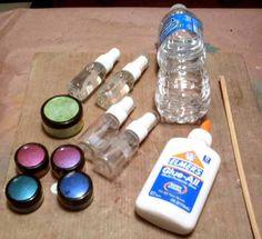 the supplies needed to make an art project are laid out on a wooden surface, including water bottles and glue