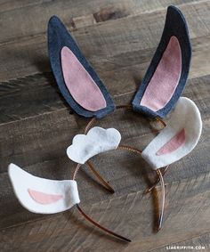 two bunny ears are sitting on top of a wooden table next to a pair of headbands