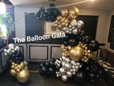 the balloon gala is going on in an elegant room with black, gold and silver balloons